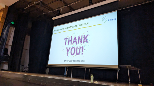 A large projector screen with the words "Thank you" 